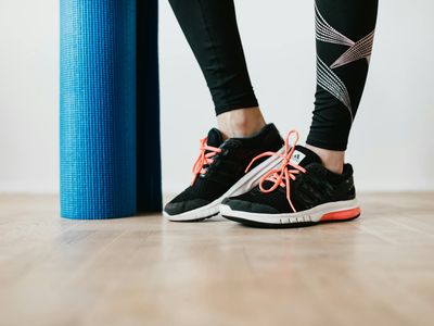 Close-up of athletic shoes on a yoga mat before a workout.